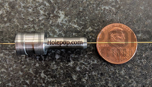 Custom edm electrode guide with brass tube inserted next to a penny for size comparisson